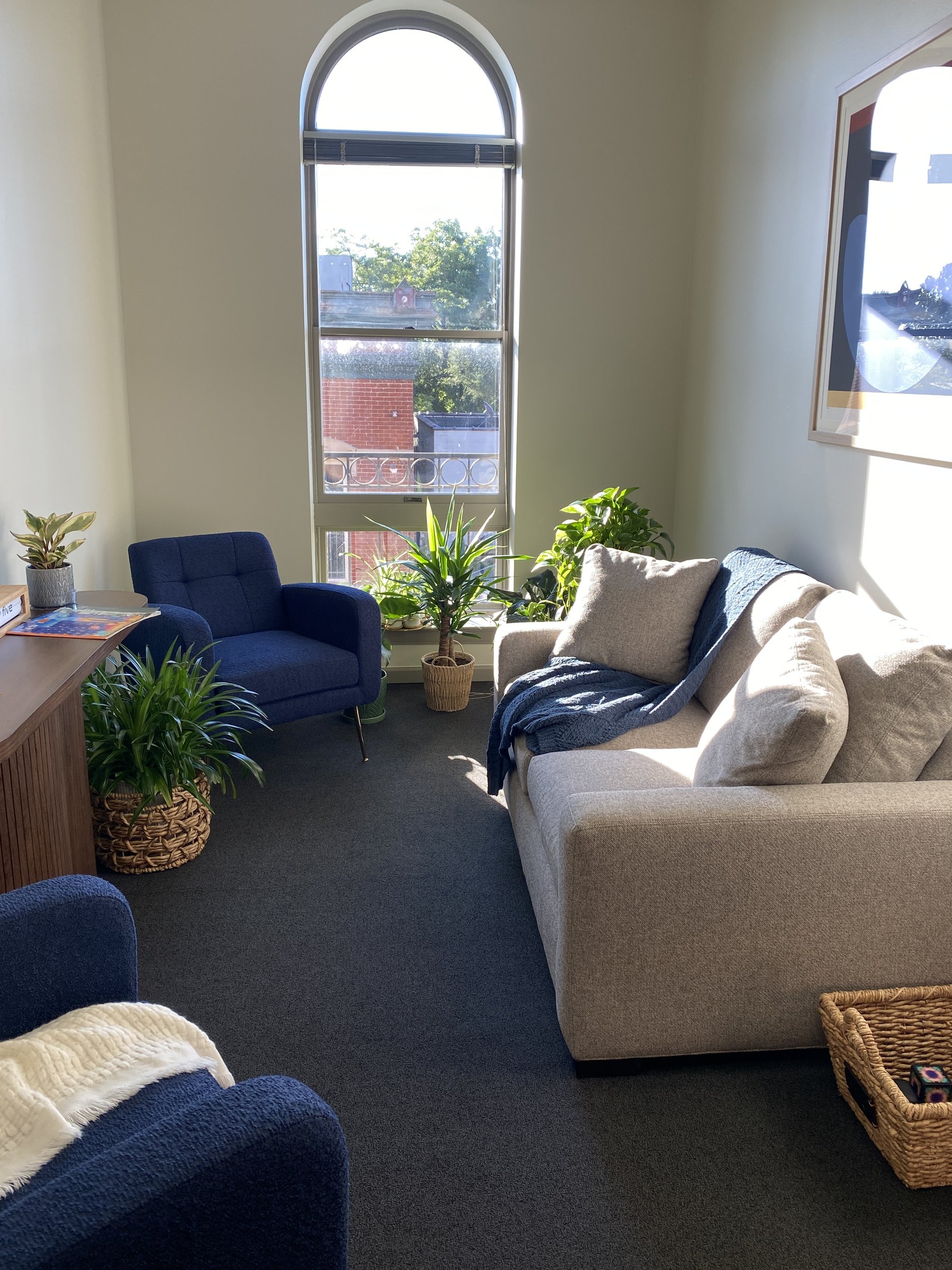 Private waiting room with a sofa, armchair, and arched window at Groundwork's Cincinnati office